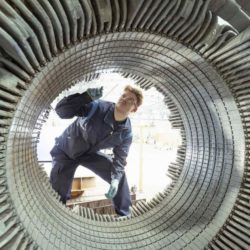 Mann prüft großes elektrisches Bauteil von Innen